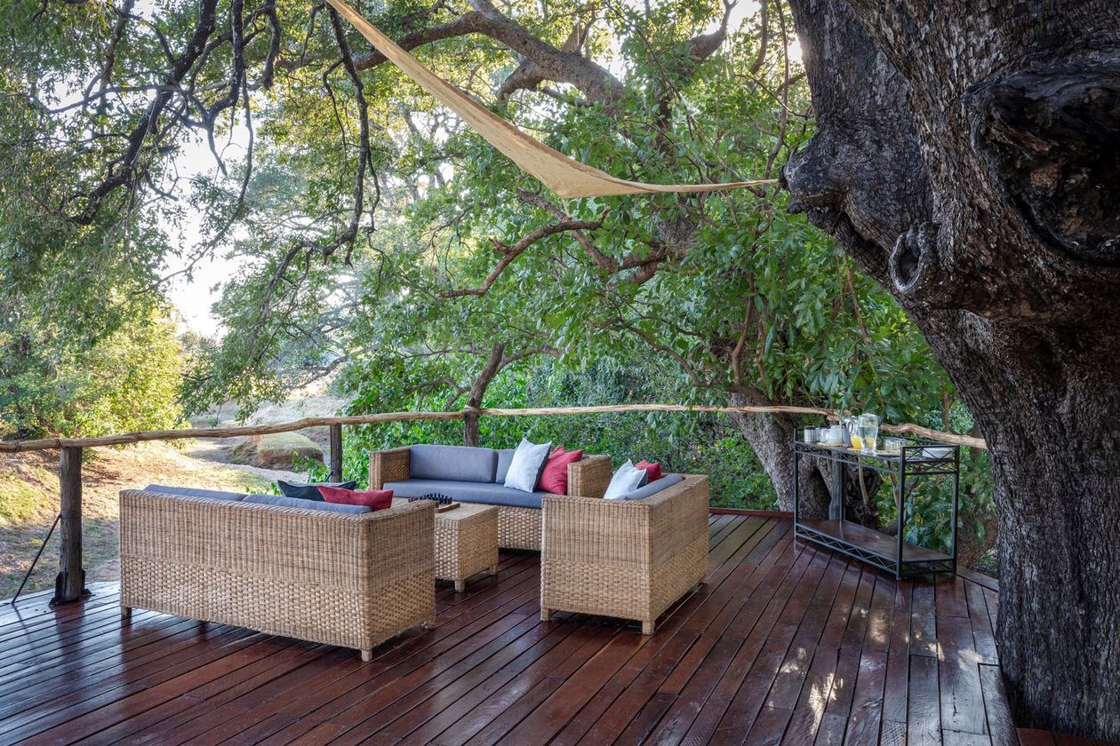 Chaises en osier sur la terrasse surplombant le lit de la rivière, Chikoko Tree Camp