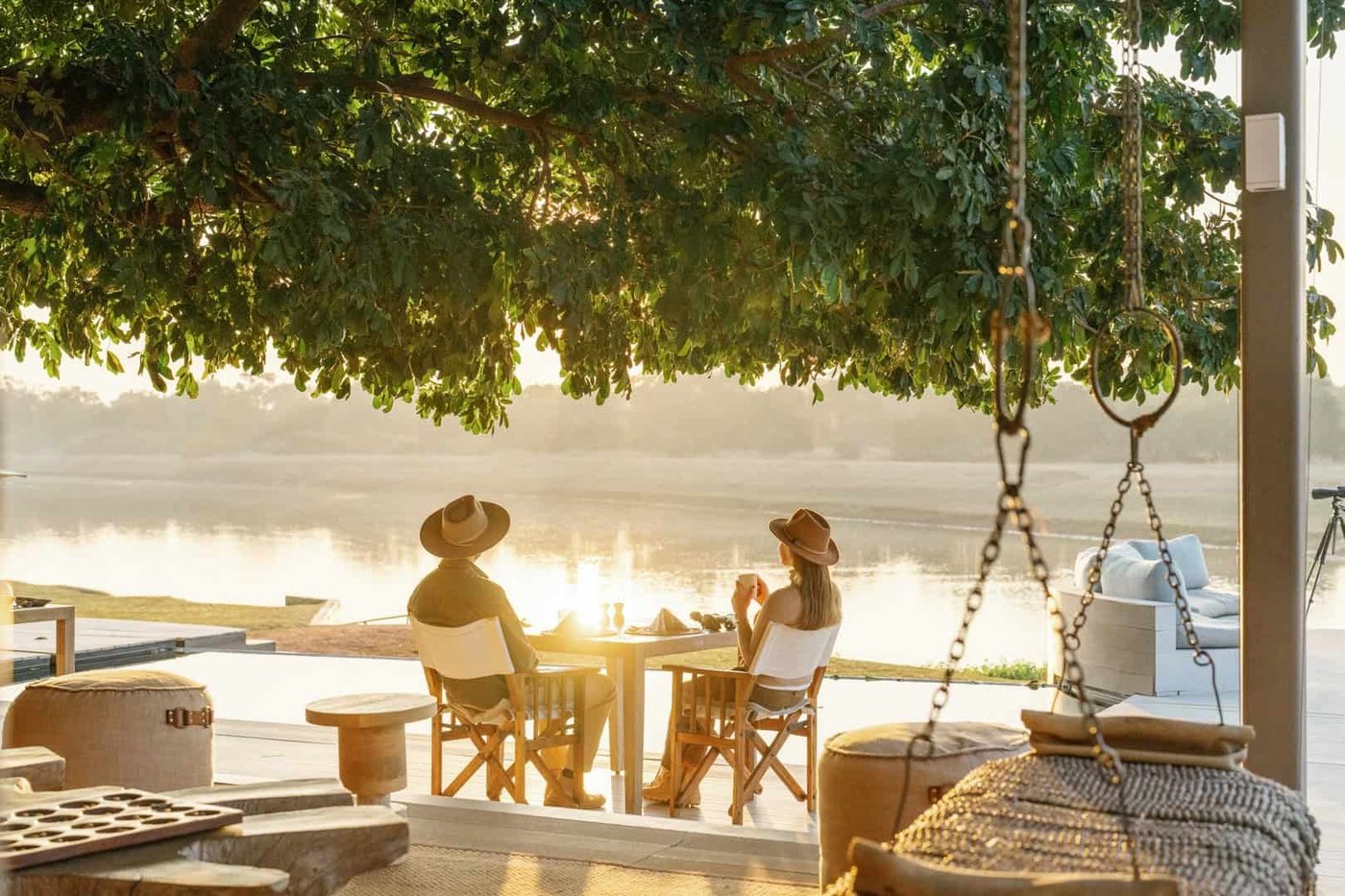 Table de petit-déjeuner au bord de la rivière au lever du soleil avec deux hôtes, Chinzombo