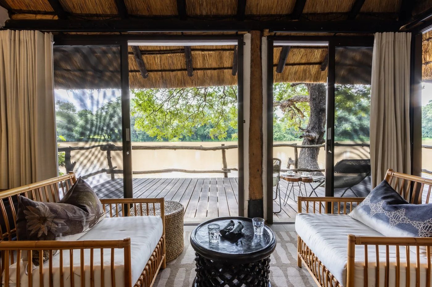 Chaises de salon en rotin donnant sur un deck privé le long du fleuve à Mfuwe Lodge