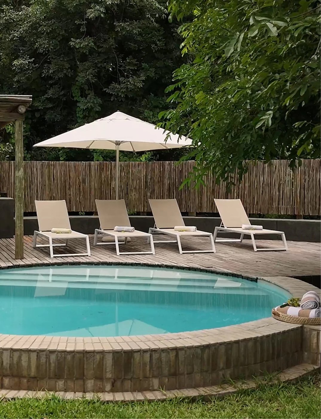 Piscine avec plongeoir rond et chaises longues sous les arbres à la maison familiale, Mfuwe Lodge