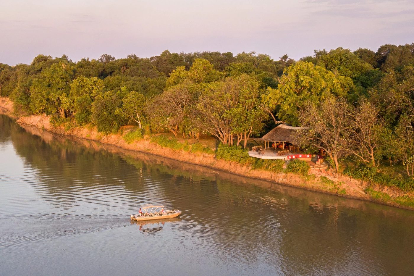 Vue le long de la rivière Luangwa avec un bateau amarré au Nkwali Camp