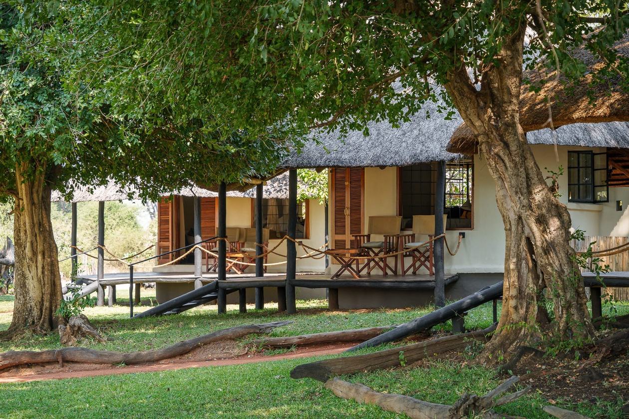 Rondavelles en brique le long d'une allée de jardin de Nsefu Camp