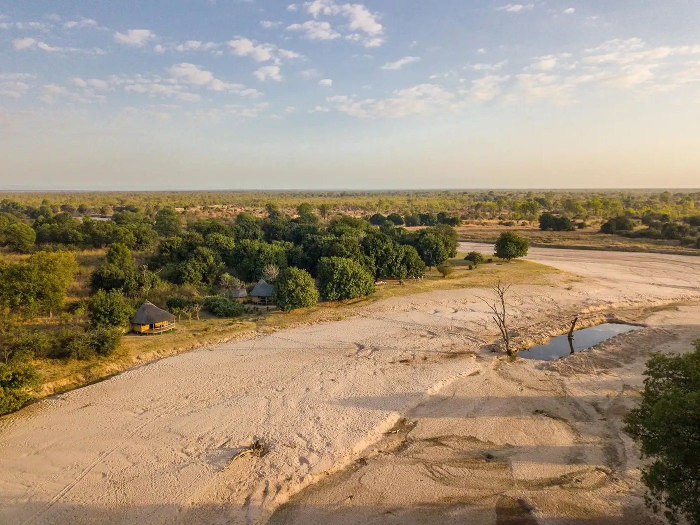 Vue aérienne du camp en chaume au bord de la rivière de sable sec à Nsolo