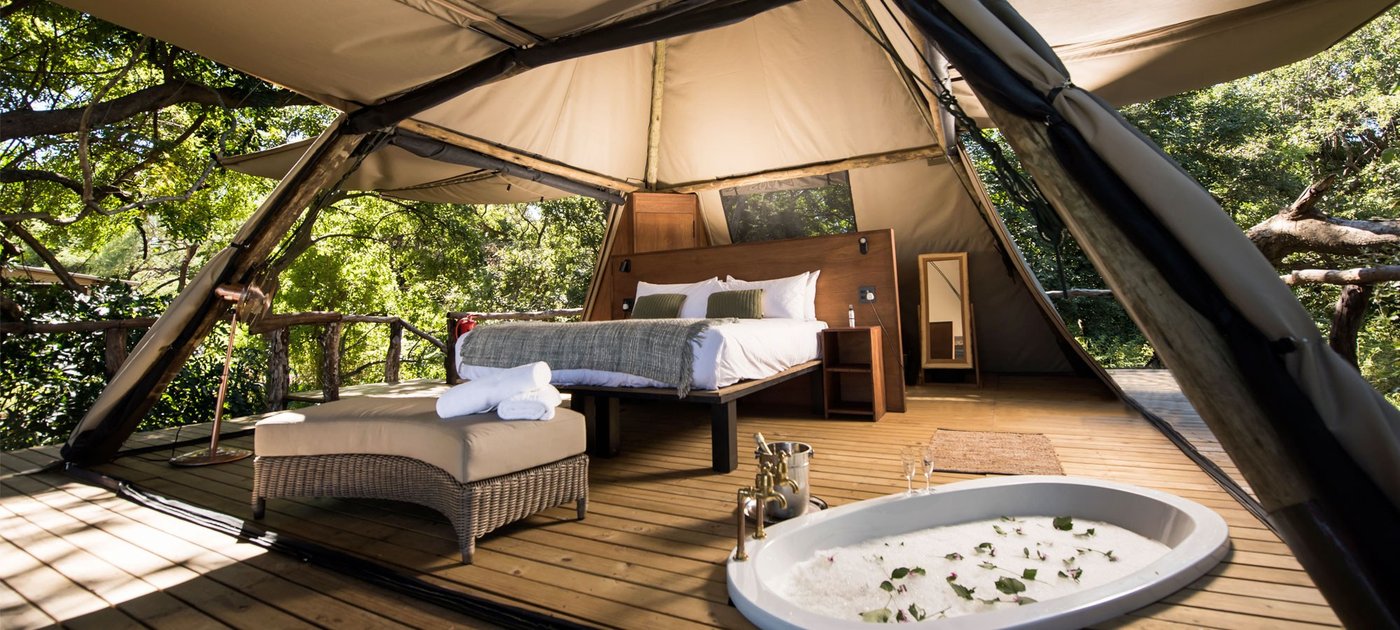 La chambre en tente de toile s'ouvre sur une terrasse avec une baignoire à Shawa Luangwa Camp