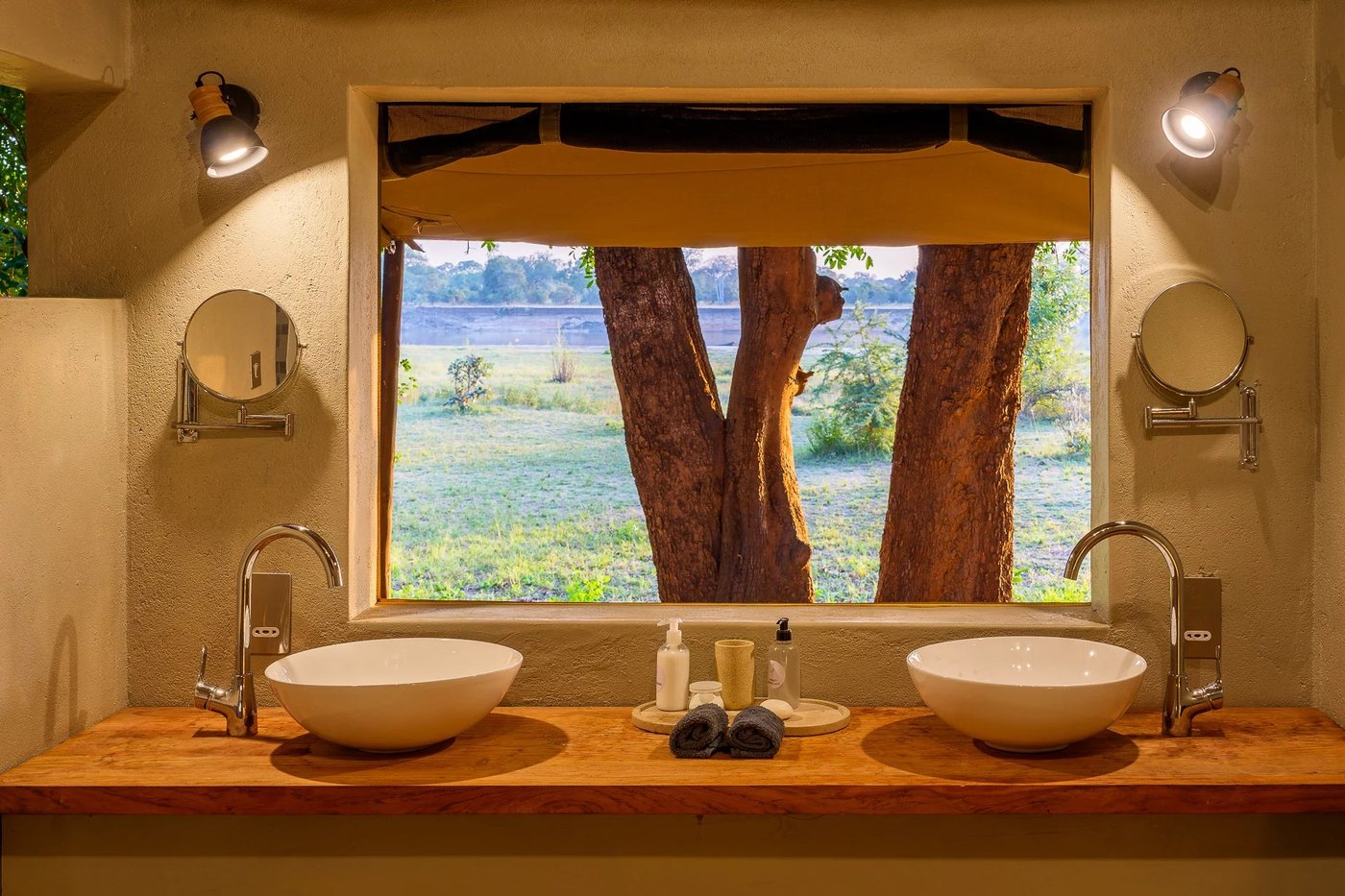 Salle de bain avec double vasque avec une fenêtre encadrant la brousse au Tena Tena