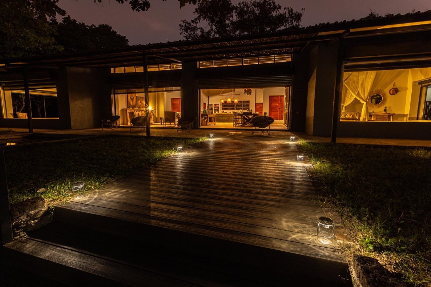 Bâtiment de lodge moderne illuminé au crépuscule, reflet sur la terrasse, Zikomo Safari Camp, South Luangwa
