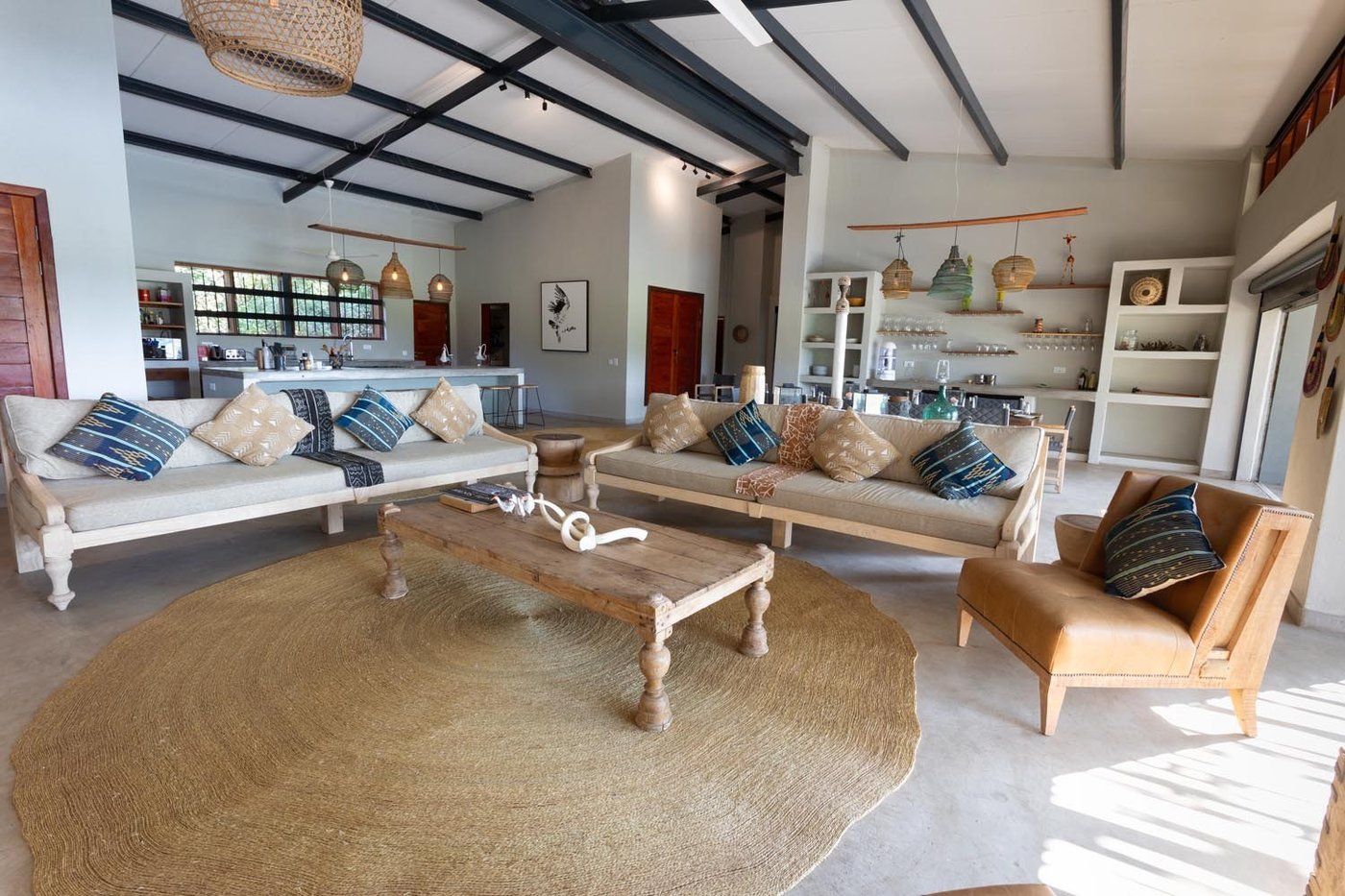Salon avec des canapés blancs et un tapis tissé à Zikomo Safari Camp